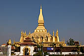 Vientiane, Laos - Surrounded by a cluster of pointed minor stupas the huge Pha That Luang shined under the warm light of the sunset.  